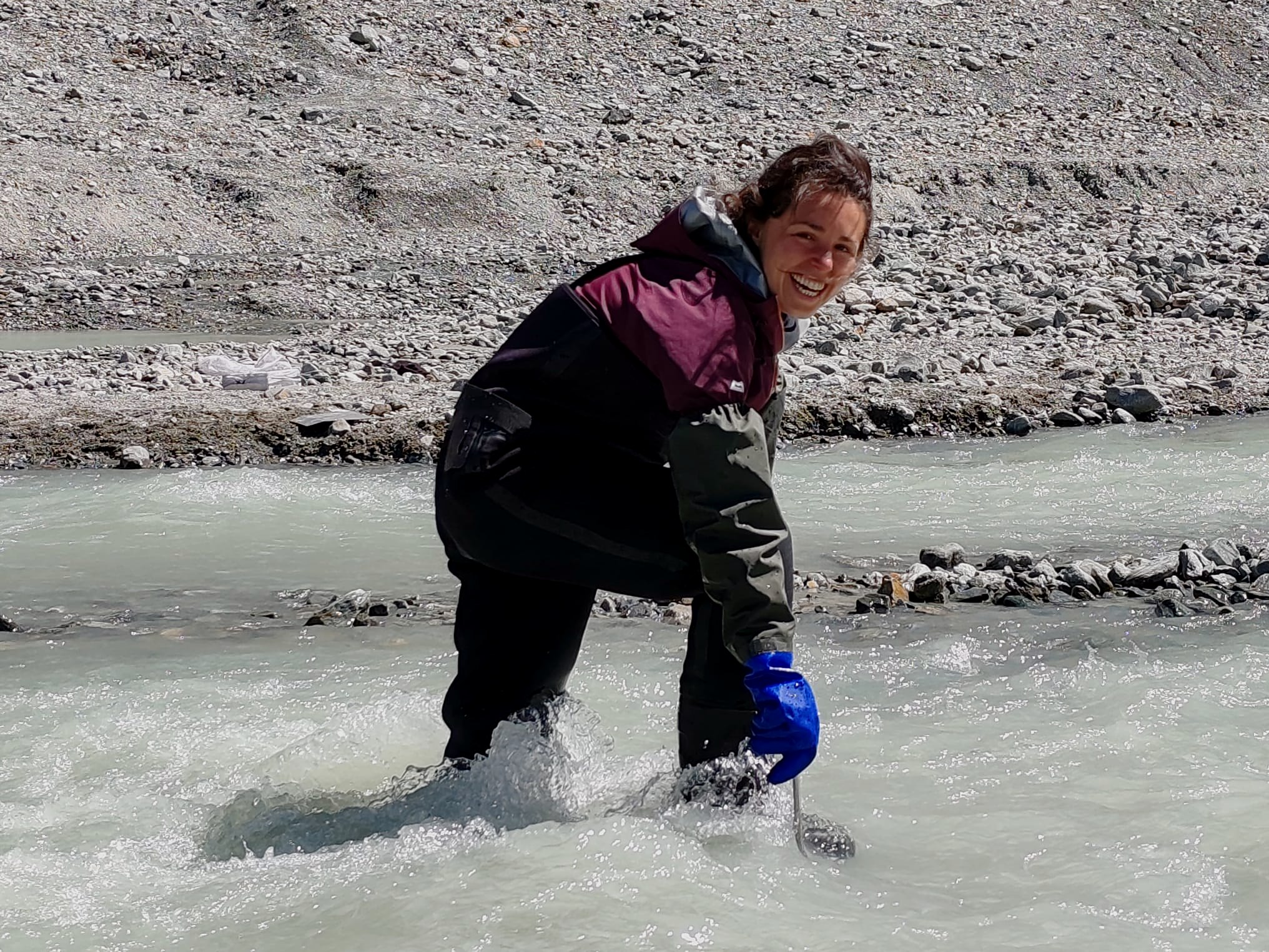 Flavia Marini guada un torrente glaciale durante un rilievo